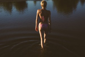 Séance photo intime en extérieur portrait femme marchant dans l'eau en maillot de bain