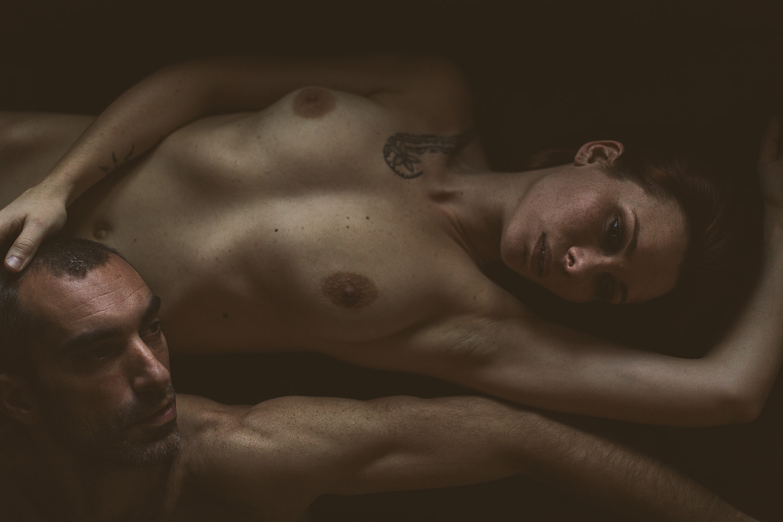 Couple nu lors d’une séance boudoir sensuelle, explorant désir et fantasme